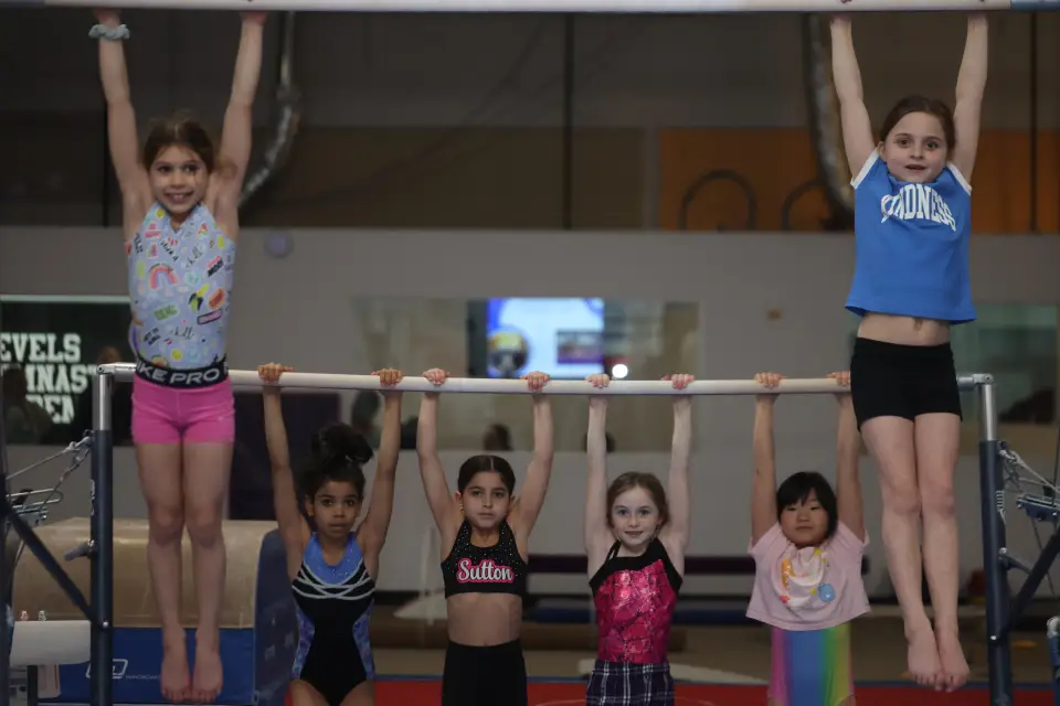 Young gymnasts practicing on bars